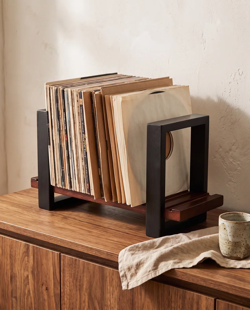Illustrative close-up of a vinyl record holder on a wooden cabinet